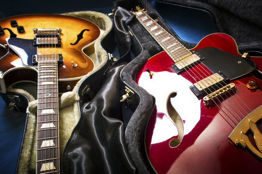 Acoustic guitars in covers in a blue background