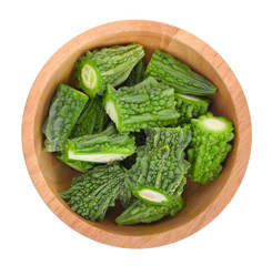 top view of bitter melon in wooden bowl isolated on white