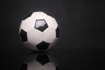 black white soccer ball on black background