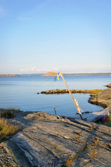 Fototapeta premium Sommardag på västkusten. En gammal svensk flagga svajar i luften ovanför klipporna. 