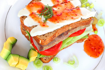Sandwich savory.Dark whole grain bread with beef,white soft cheese and vegetables- slices of fresh avocado and lettuce,flavored with sweet tomato sauce,cooked on the honey basis.Mediterranean cuisine