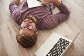 Man lying on the floor with modern technology