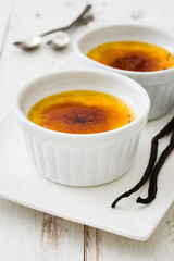 Traditional French creme brulee dessert with caramelized sugar on top, on wooden table

