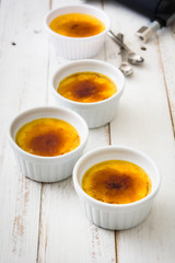 Traditional French creme brulee dessert with caramelized sugar on top, on wooden table

