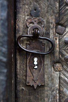 Ornamental vintage iron door handle on wooden door