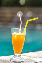 orange juice on the background of the pool