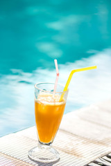 orange juice on the background of the pool