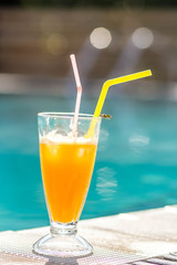 orange juice on the background of the pool