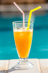 orange juice on the background of the pool