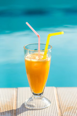 orange juice on the background of the pool