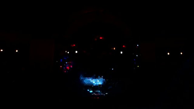 Huge glowing disco ball. Spotlights illuminated disco ball flares.