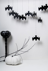 halloween with black silhouettes of bats and pumpkins with a branch of a tree on a white background