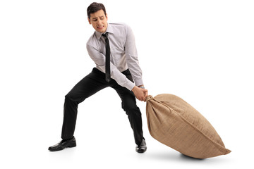 Young businessman pulling a burlap sack
