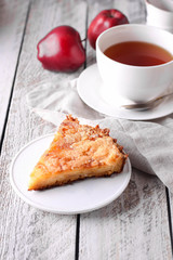 Slice of homemade apple pie on a wooden background. Autumn breakfast with fruit pie and tea.