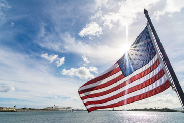 American flag waving with the sunbeams behind it