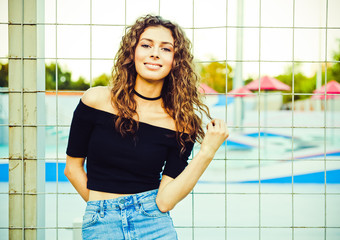 Fashionable portrait of a beautiful brunette girl with long hair posing near the skate park. having fun