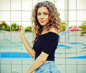 Outdoor Summer Fashionable sexy sensual portrait of a beautiful brunette girl with long hair posing, having fun near the skate park. Youth and beauty.