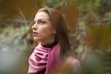 Naklejka premium Portrait of young woman in pink topcoat at autumn day