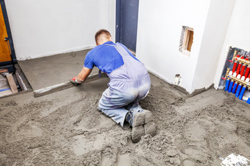 Employee performs sand and cement screed floor. Sand and cement floor screed