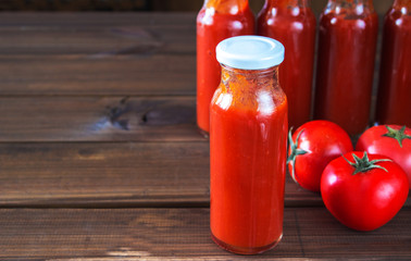 bottles of homemade ketchup and tomatoes. tomato sauce