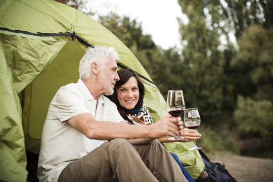 Senior couple sitting with wine in a tent