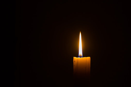 horizontal photo of candle with straight frame on black background with copyspace