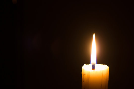 horizontal photo of closeup candle on black background with copyspace