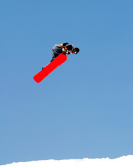 Snowboarder crabbing his Snowboard during a Trick Jump