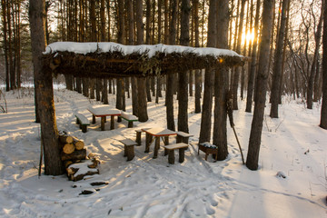 wooden gazebo in a snowy forest