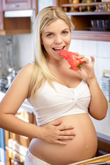 woman eating pepper in the kitchen and smiles,