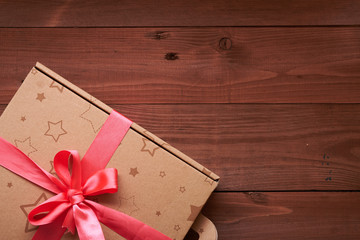 gift wrap with a pink ribbon on a wooden table