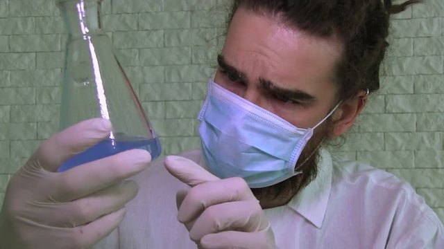 A Laboratory Assistant Is Analising Contents Of A Blue Liquid In A Flask