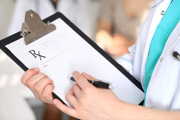 Fototapeta premium Close-up of a female doctor while filling up medical prescription