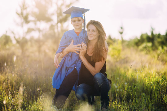 Portrait of mother with son wearing graduation gown