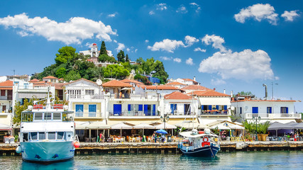 Fototapeta na wymiar Skiathos town on Skiathos Island, Greece. Beautiful view of the old town with boats in the harbor.