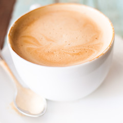 a cups of cappuccino coffee with spoon and white dish, selective focus