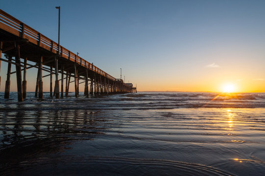 Tide coming in during a beautiful Dramatic Sunset at Newport beach Pier in Orange county, California