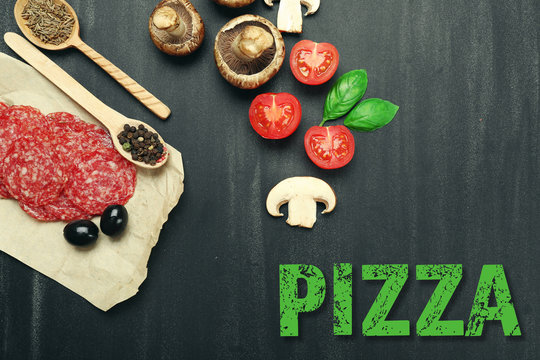 Ingredients for tasty pizza and word PIZZA on dark background.
