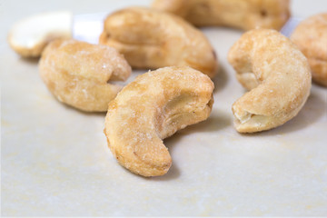 Cashew nuts coated with sugar and salt on tile background / Sele