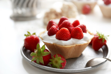 Tasty cake with strawberries on silver plate