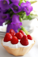 Tasty cake with strawberries on table