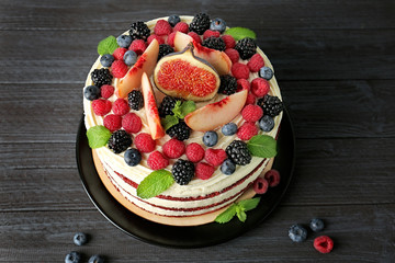 Tasty cake with berries on wooden background