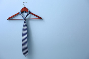 Male tie hanging on the rack, blue background