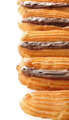 Delicious eclairs with chocolate in a row on white background