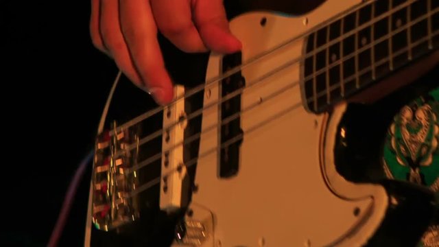 Closeup Guitarist Touches Electric Guitar Strings in Night Bar