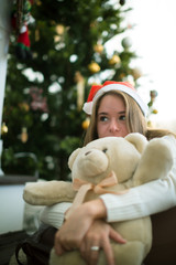 Obraz na płótnie Canvas Sensual young girl hugs teddy bear in christmas eve