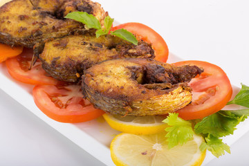 Fried fish in a plate with ingredients