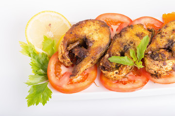 Fried fish in a plate with ingredients