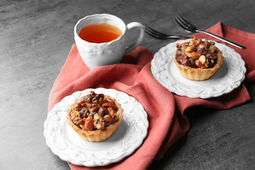 Cup of tea and tasty tarts on table