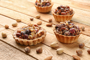 Delicious nut cakes on wooden table